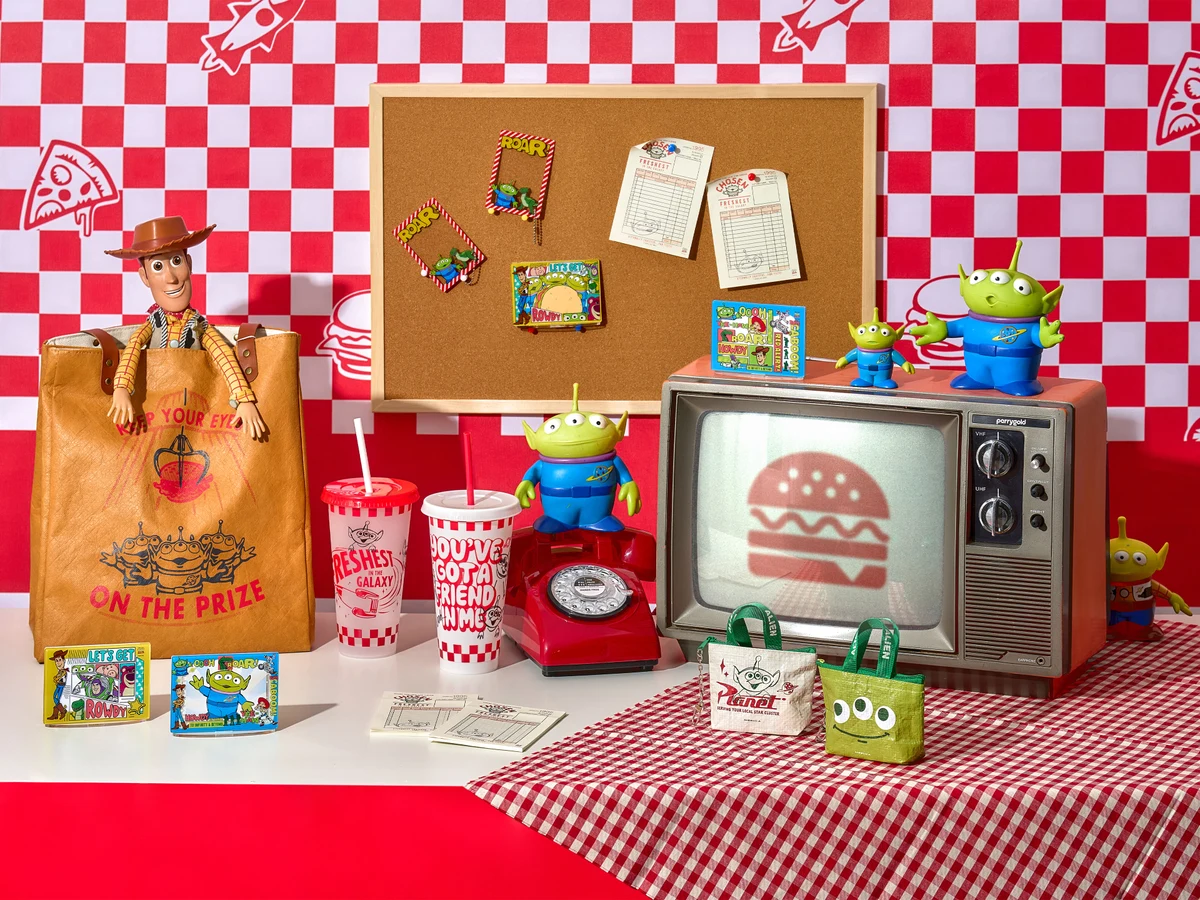 Dino × Toy Story bags, cups and accessories in a red and white styled scene